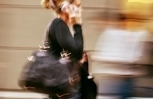 Woman talking on a cell phone in a hurry — Stock Photo, Image