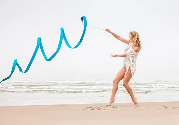 Gymnaste femme danse avec ruban sur la plage — Photo