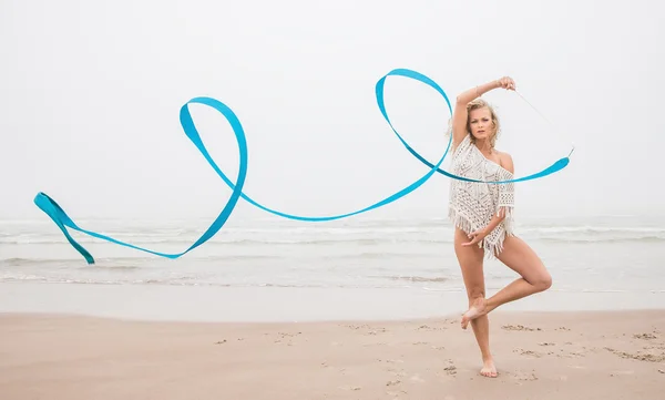 Ginasta dança com fita na praia — Fotografia de Stock