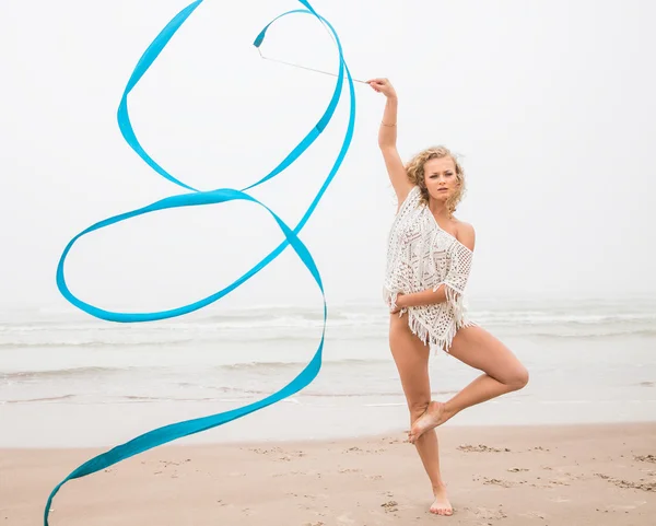 Ginasta dança com fita na praia — Fotografia de Stock