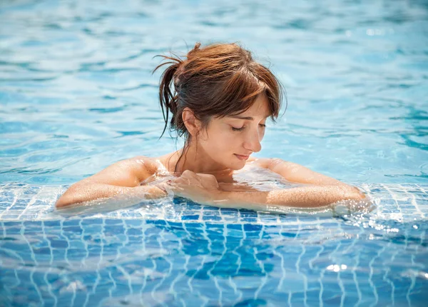 Jeune femme se relaxant dans une piscine — Photo