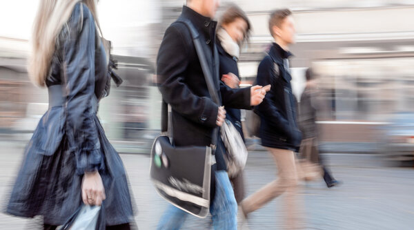 Группа молодых людей идет по улице
