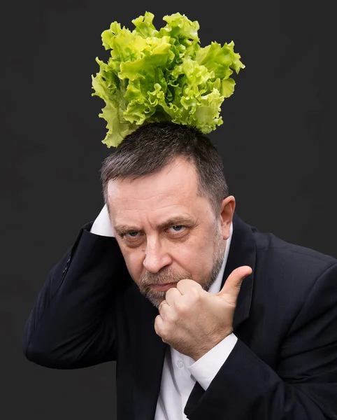 Hombre sosteniendo y comiendo lechuga — Foto de Stock