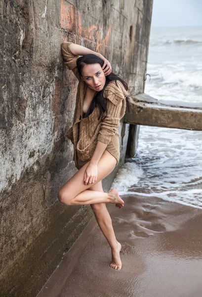 Woman near concrete constructions on the sea shore — Stock Photo, Image