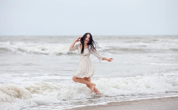 Woman in the cold sea waves — Stock Photo, Image