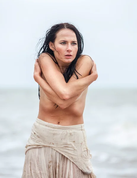 Bevroren jonge vrouw op de achtergrond koud zee — Stockfoto