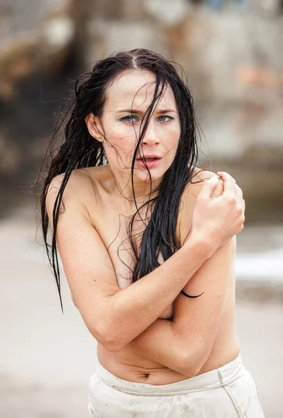 Frozen young woman on the cold sea beach — Stock Photo, Image