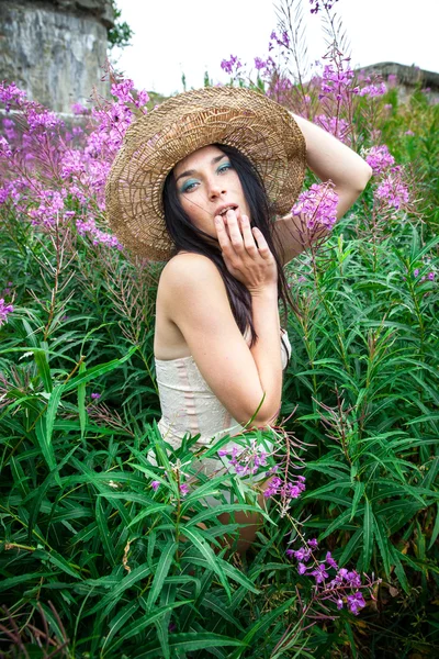 Menina em chapéu de palha contra a natureza e parede velha fundo — Fotografia de Stock