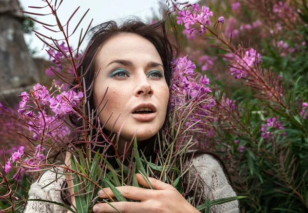 Schönes Mädchen zwischen den Blumen — Stockfoto