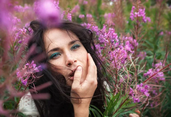 Schönes Mädchen zwischen den Blumen — Stockfoto