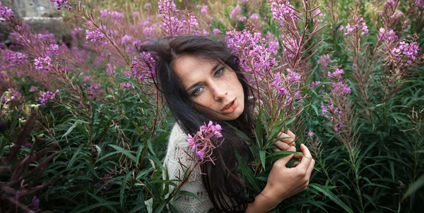 Schönes Mädchen zwischen den Blumen — Stockfoto