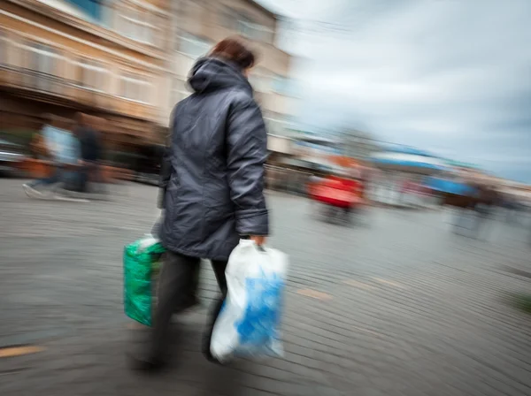 Nő egy kabát vásárlás műanyag zacskók — Stock Fotó