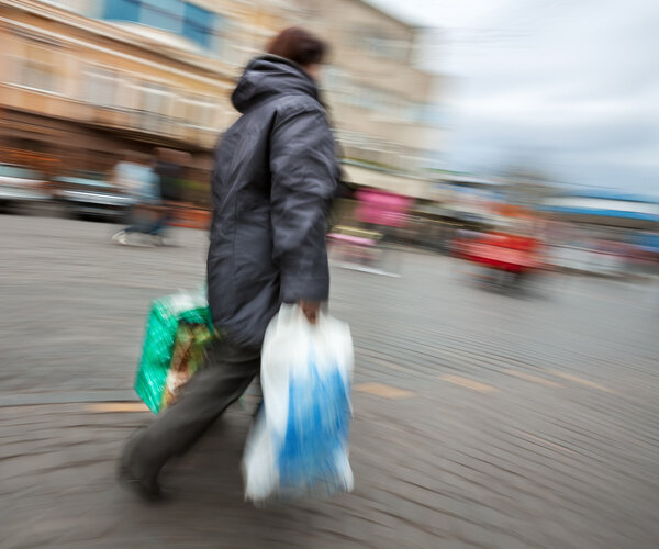 woman in a jacket with shopping plastic bags