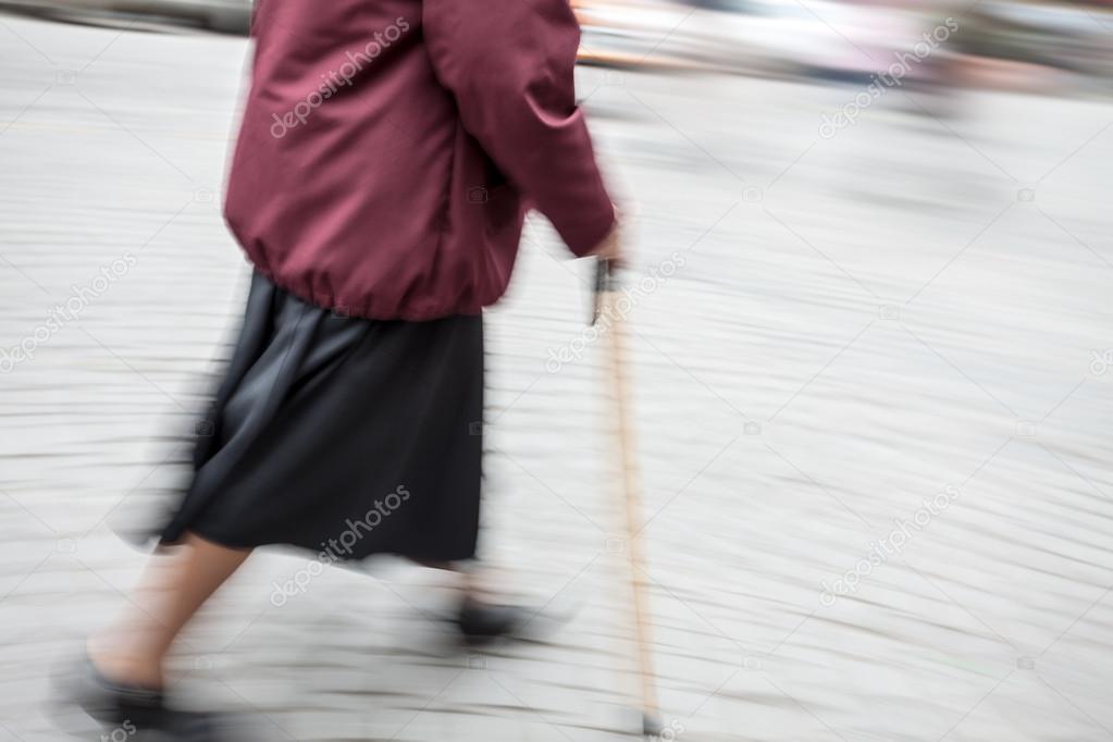 woman with a cane walking down the street