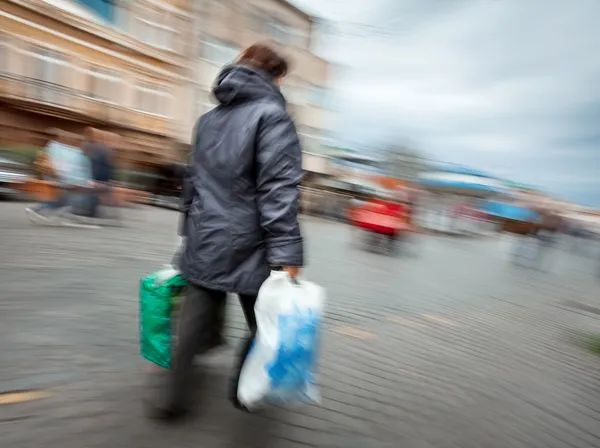 Donna in giacca con sacchetti di plastica shopping — Foto Stock