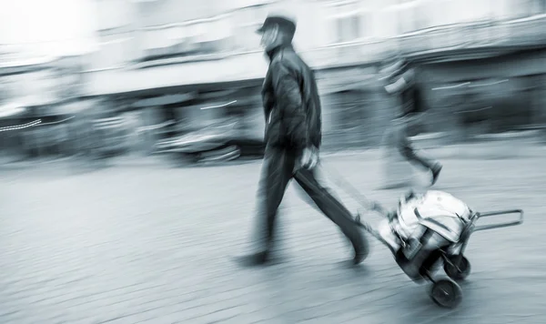 Mann mittleren Alters trägt den Einkaufswagen mit Tasche — Stockfoto