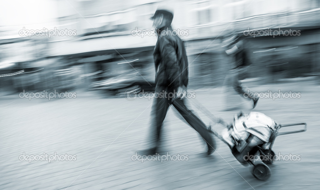 Middle-aged man carries the cart with bag
