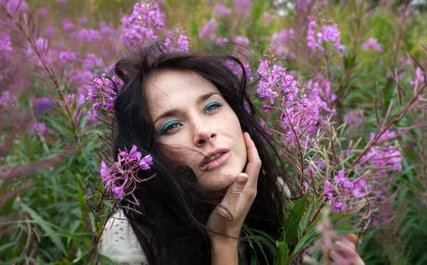 Schönes Mädchen zwischen den Blumen — Stockfoto