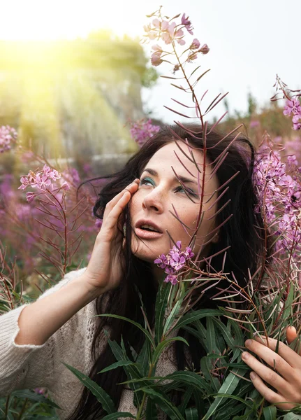 Mooi meisje tussen de bloemen — Stockfoto