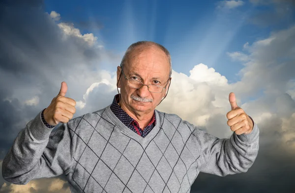 Senior man with glasses enjoying the outdoors with cloudy sky — Stock Photo, Image