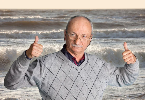 Старший чоловік насолоджується на відкритому повітрі з хвилястим морем — стокове фото