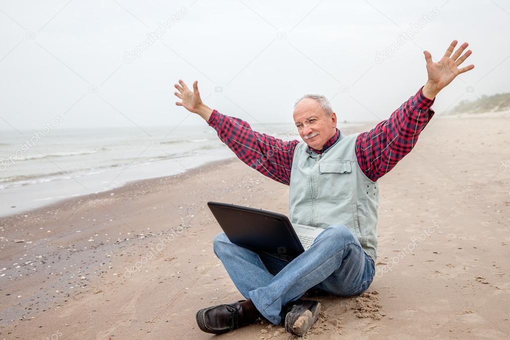 Old man with notebook on beach