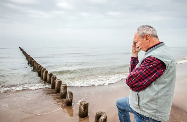 Zamyšleně starší muž, který stojí na pláži — Stock fotografie