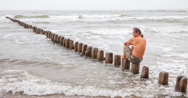 Muž středního věku, sedí u moře — Stock fotografie