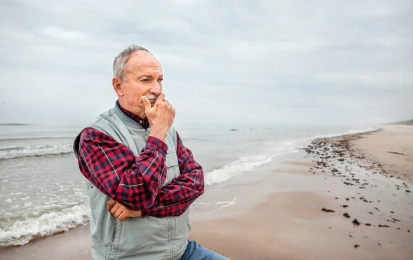 Thoughtful elderly man standing on the beach — Stock Photo, Image