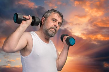 Dambıllarla egzersiz yapan adam.