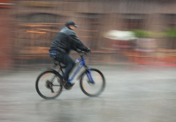 Cyklist Rider genom gatorna på en regnig dag — 图库照片