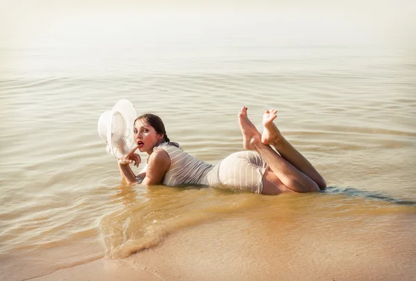 Mujer de sombrero blanco posando contra el mar —  Fotos de Stock