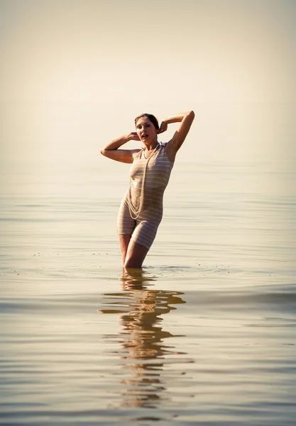 Kvinna poserar mot havet — Stockfoto