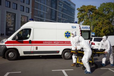 KYIV, UKRAINE - 12 Ekim 2021: Ambulans ekibi, COVID-19 salgını sırasında bir hastayı sedyeyle bir arabadan mobil hastaneye taşıdı
