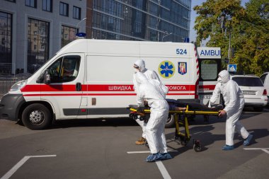 KYIV, UKRAINE - 12 Ekim 2021: Ambulans ekibi, COVID-19 salgını sırasında bir hastayı sedyeyle bir arabadan mobil hastaneye taşıdı