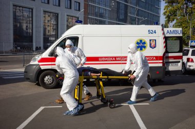 KYIV, UKRAINE - 12 Ekim 2021: Ambulans ekibi, COVID-19 salgını sırasında bir hastayı sedyeyle bir arabadan mobil hastaneye taşıdı