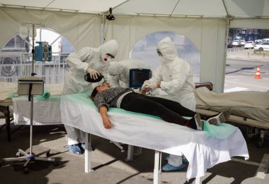 KYIV, UKRAINE - 12 Ekim 2021: Aktivistler COVID-19 hastaları için geçici canlandırma bölümü sahnesiyle performans sergiliyorlar. Doktorlar bir hastaya acil resüsitasyon uygularlar.