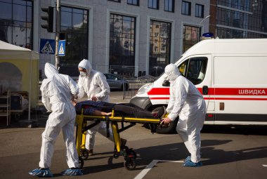 KYIV, UKRAINE - 12 Ekim 2021: Ambulans ekibi, COVID-19 salgını sırasında bir hastayı sedyeyle bir arabadan mobil hastaneye taşıdı