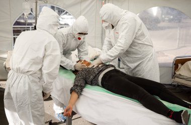 KYIV, UKRAINE - 12 Ekim 2021: Aktivistler COVID-19 hastaları için geçici canlandırma bölümü sahnesiyle performans sergiliyorlar. Doktorlar bir hastaya acil resüsitasyon uygularlar.