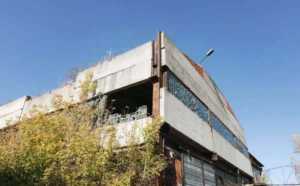 旧工业建筑的墙壁 有破碎的玻璃板和生锈的金属板 — 图库照片