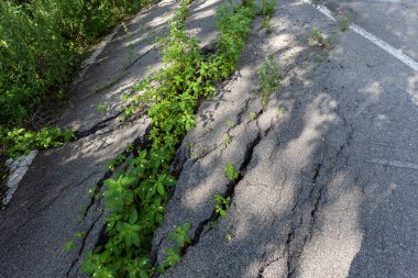 Şişmiş asfalt. Toprak yığınının doğal afetlerinin yol sonuçlarını yok etti. Asfalt heyelan tarafından kaydırıldı.