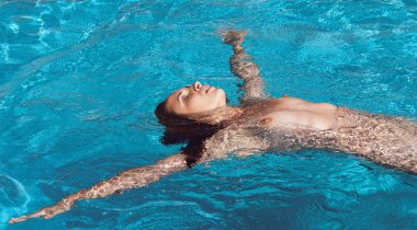 Açık havada çıplak bir kadın. Yüzme havuzunda genç ve güzel bir kadın..