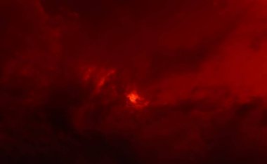 Koyu kırmızı dramatik bulutlar ve güneş parlıyor. Doğal arkaplan ve doku