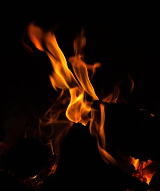 Alevler, yangın arka planı ve doku. Odunlu şömine ve arka planda ateş.