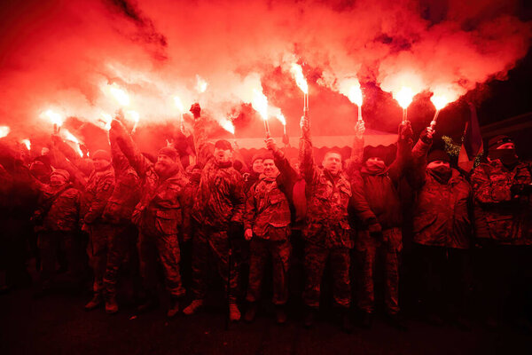 КИЕВ, УКРАИНА - 19 января 2022 года: Массовый протест против произвола и диктатуры возле офиса президента Украины Владимира Зеленского. Молодые люди сжигают факелы и факелы во время митинга