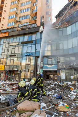 KYIV, UKRAINE - 25 Şubat 2022 Rusya 'nın Ukrayna' ya karşı savaşı. Kurtarma ekibi, Kyiv 'deki bir Rus roketi tarafından yok edilen bir evin yakınında çalışıyor.