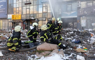 KYIV, UKRAINE - 25 Şubat 2022 Rusya 'nın Ukrayna' ya karşı savaşı. Kurtarma ekibi, Kyiv 'deki bir Rus roketi tarafından yok edilen bir evin yakınında çalışıyor.