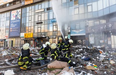 KYIV, UKRAINE - 25 Şubat 2022 Rusya 'nın Ukrayna' ya karşı savaşı. Kurtarma ekibi, Kyiv 'deki bir Rus roketi tarafından yok edilen bir evin yakınında çalışıyor.