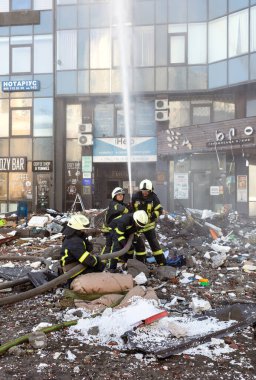 KYIV, UKRAINE - 25 Şubat 2022 Rusya 'nın Ukrayna' ya karşı savaşı. Kurtarma ekibi, Kyiv 'deki bir Rus roketi tarafından yok edilen bir evin yakınında çalışıyor.