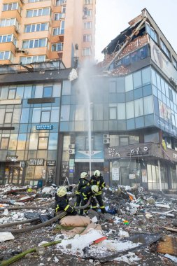 KYIV, UKRAINE - 25 Şubat 2022 Rusya 'nın Ukrayna' ya karşı savaşı. Kurtarma ekibi, Kyiv 'deki bir Rus roketi tarafından yok edilen bir evin yakınında çalışıyor.